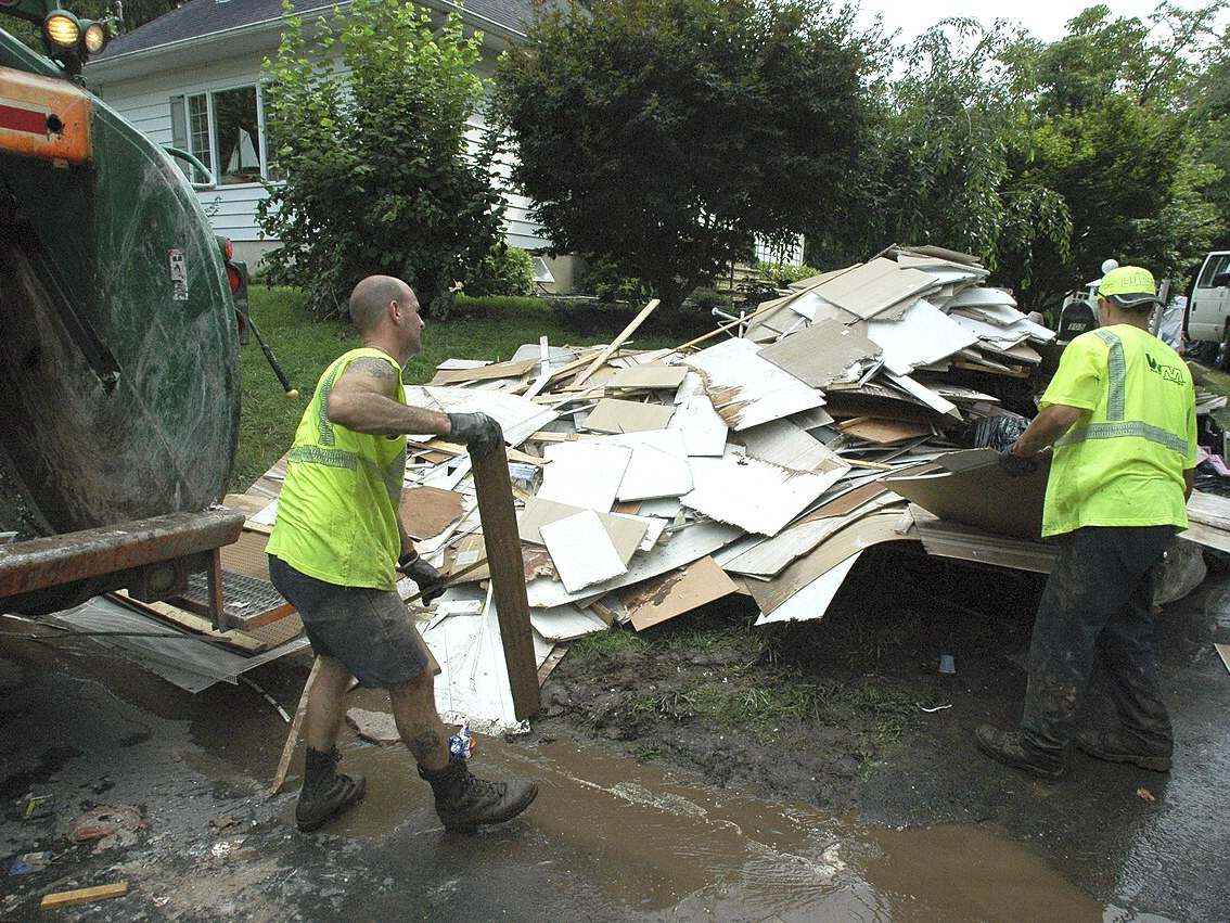 A cleanup crew loading flood damaged material into a truck after a water loss