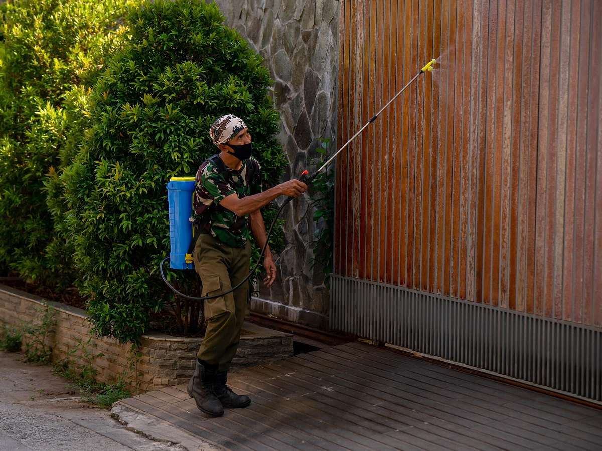 Worker applying a spray treatment with a backpack sprayer