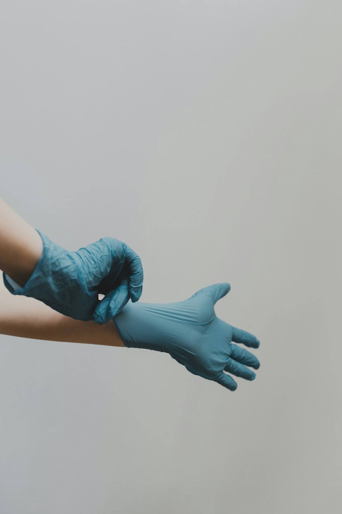 Technician pulling on blue protective gloves before antimicrobial treatment work in a Tulsa OK home