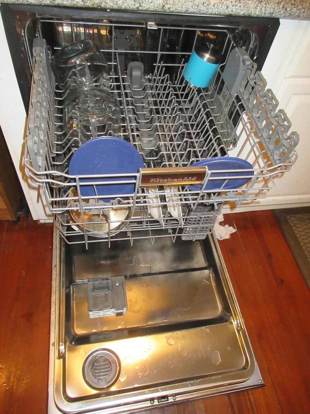 An open dishwasher showing its racks inside a kitchen