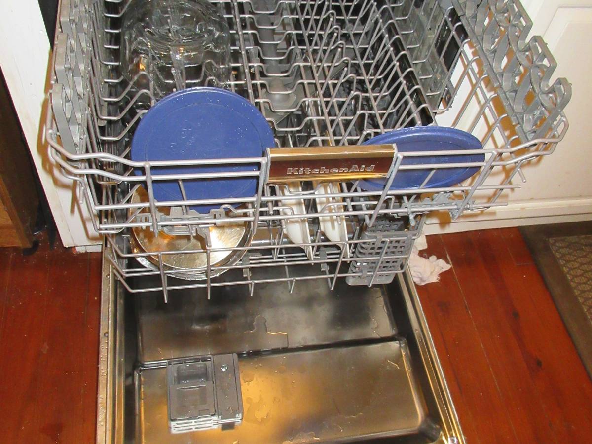 An open dishwasher with its racks pulled out in a home kitchen