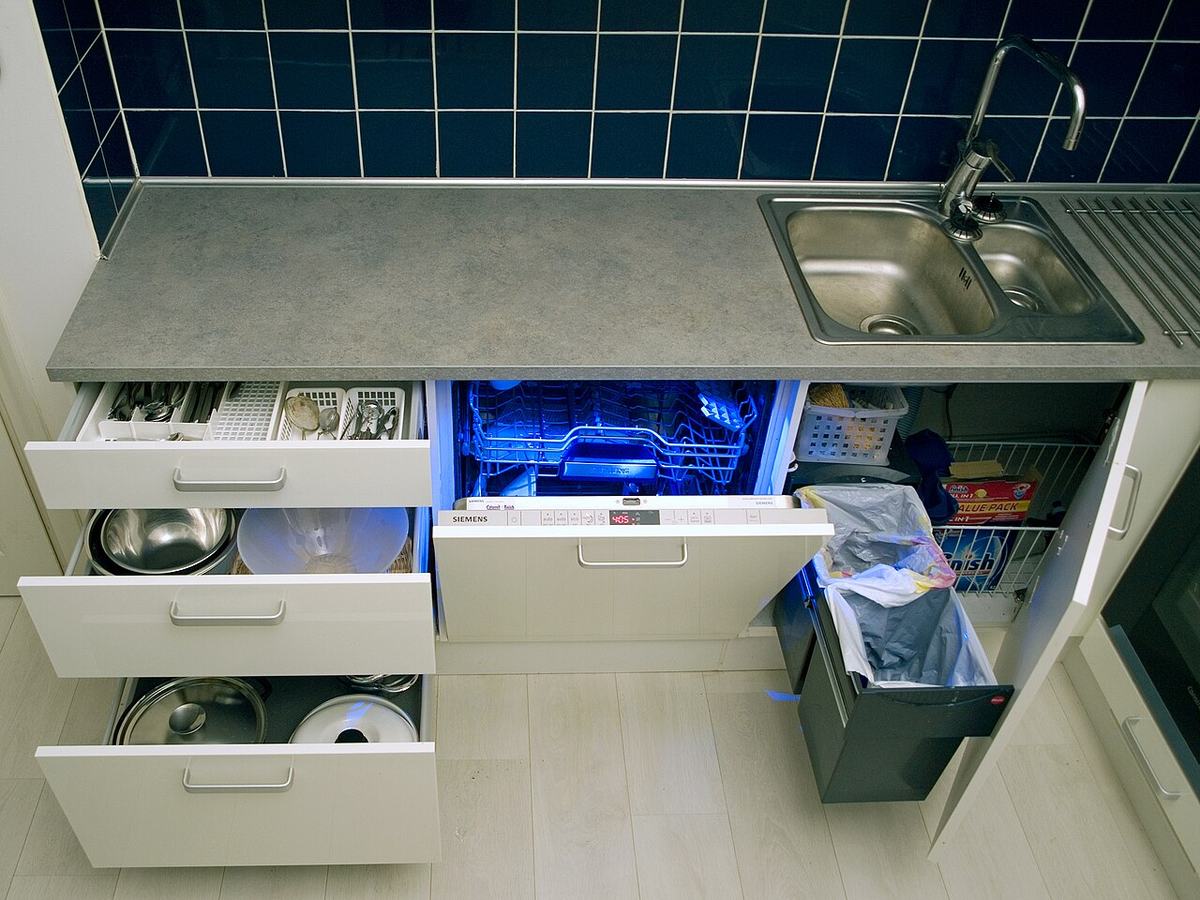 Open dishwasher drawer under a kitchen counter, one of the appliance connections checked monthly for slow leaks in Tulsa homes