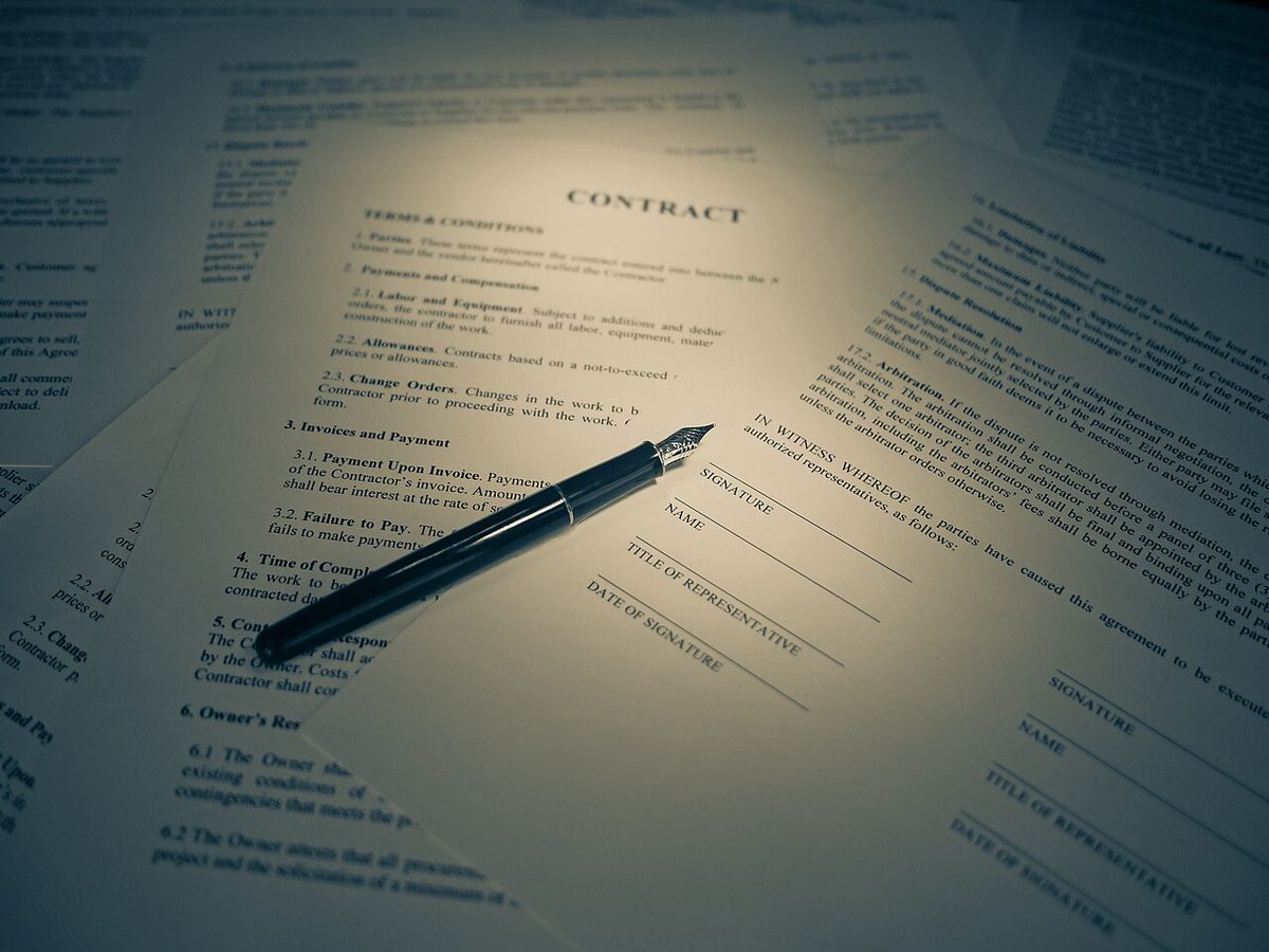 Homeowners insurance paperwork being signed at a desk