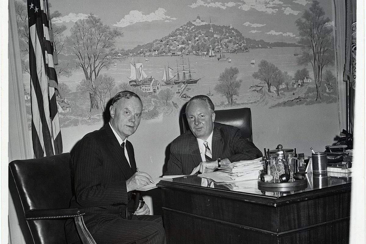 A man signing paperwork at a desk, the moment a claim file becomes official
