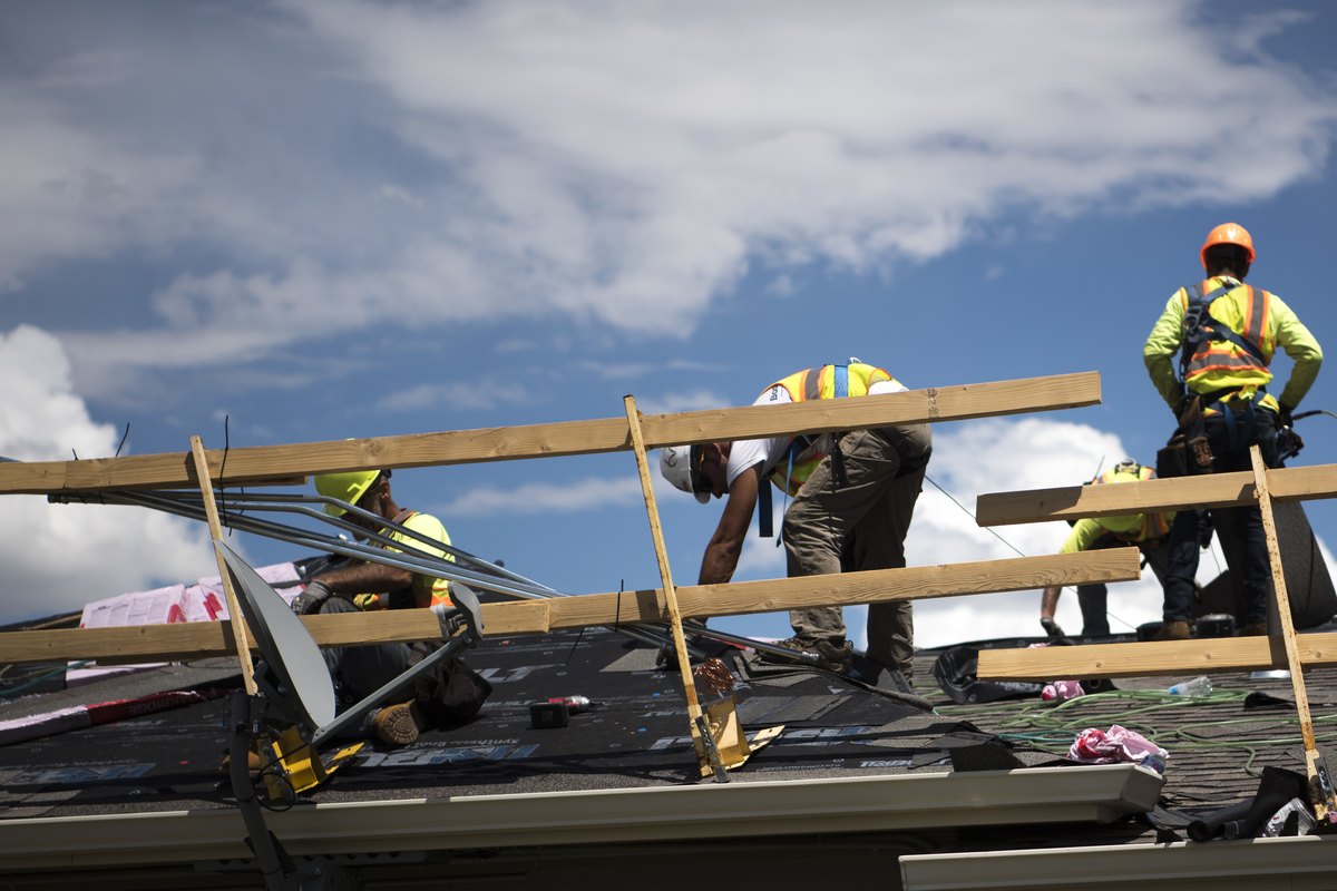 Roofers installing new shingles during a roof repair
