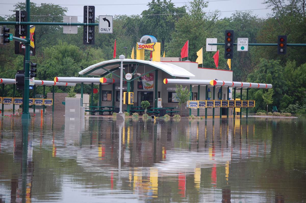 A flooded commercial corridor with businesses standing in water