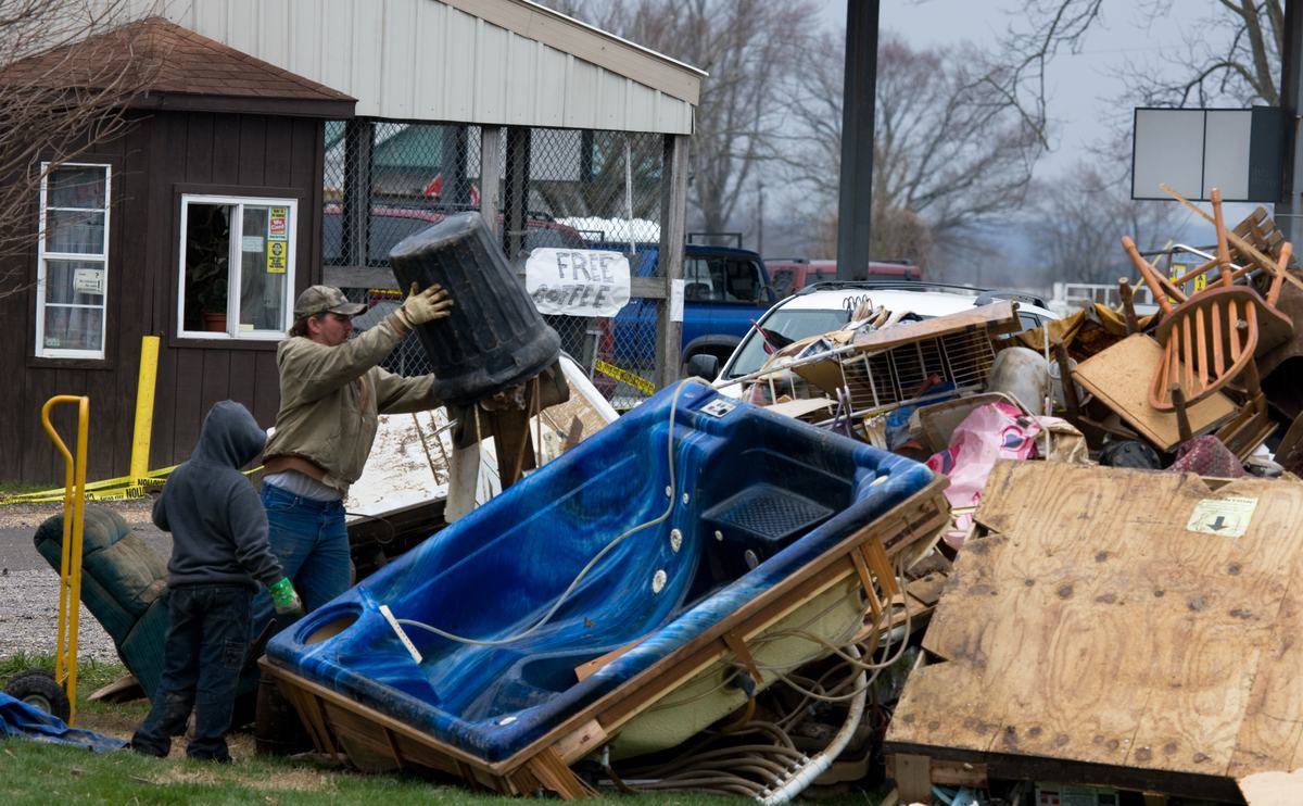 Residents hauling flood damaged belongings and debris out of a home