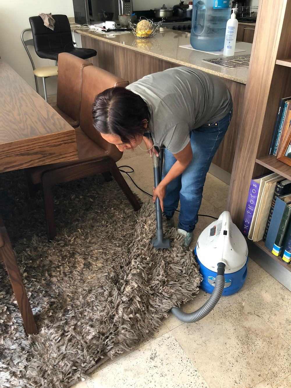 A worker deep cleaning a carpet with a machine after water damage
