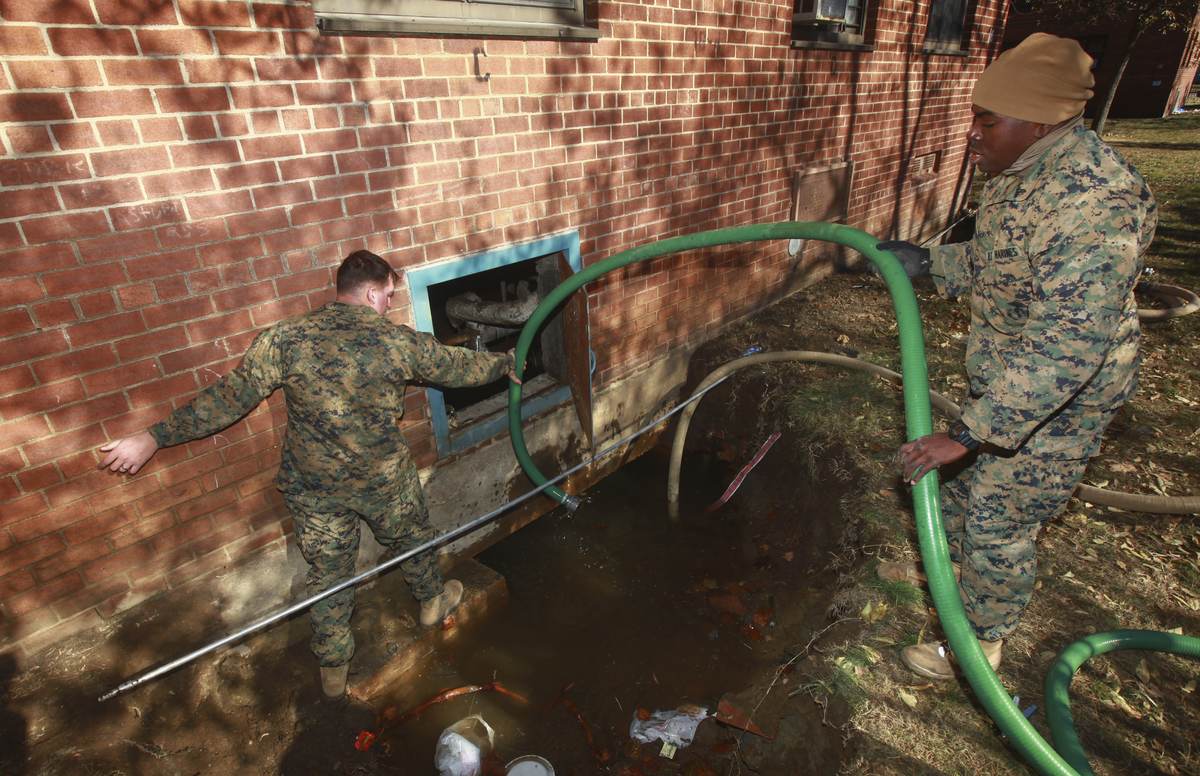 Pumping water out of a flooded basement window with hoses