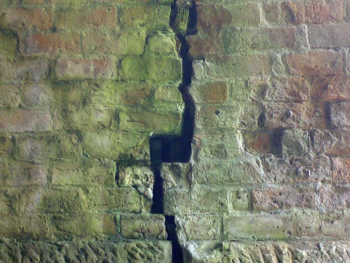 A long crack running down a masonry wall