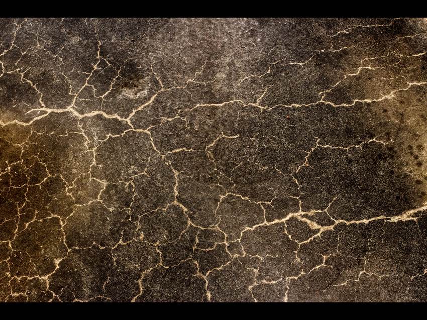 Network of cracks across a concrete floor slab