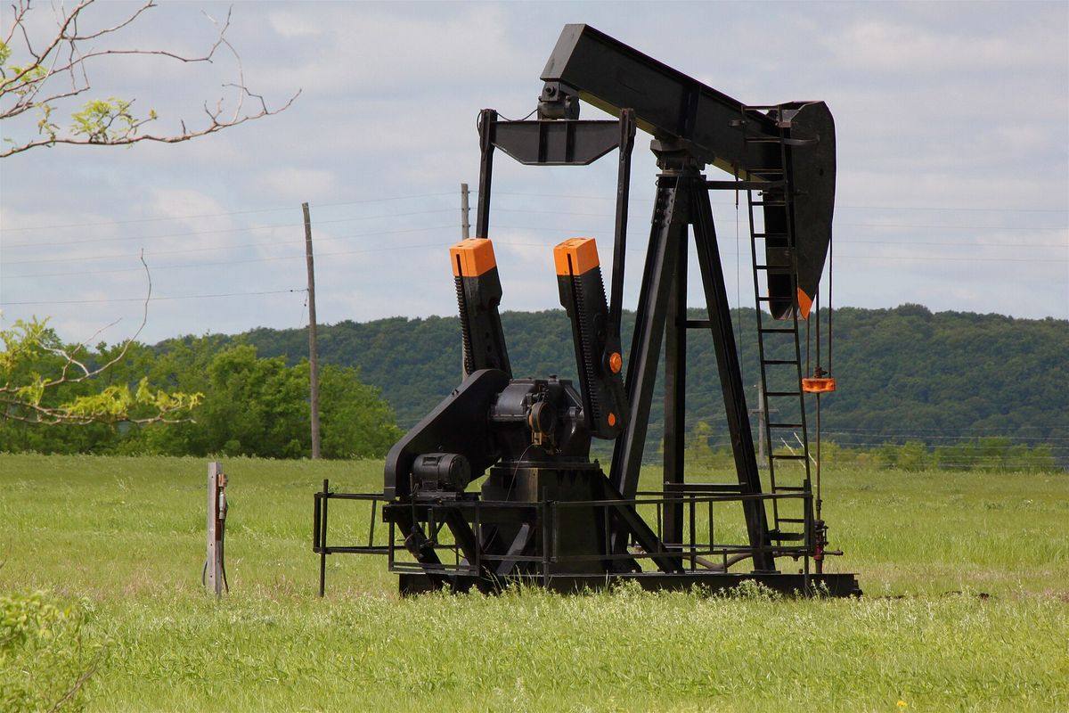 Pumpjack working in a grassy field in the Glenn Pool oil field country near Glenpool, Oklahoma