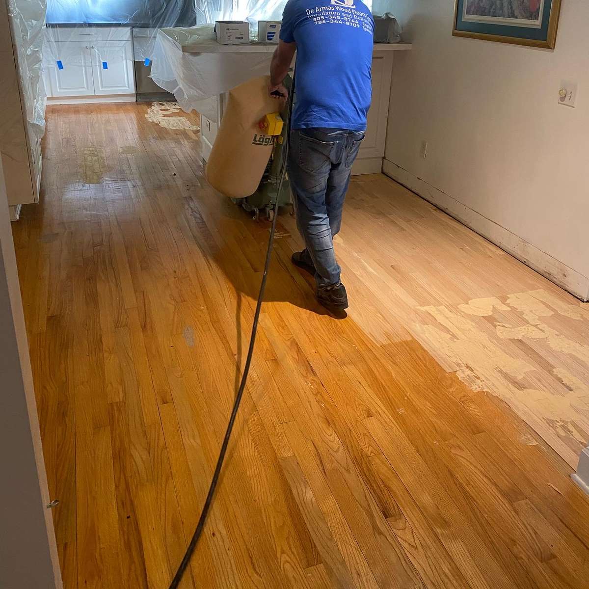 A worker refinishing a hardwood floor