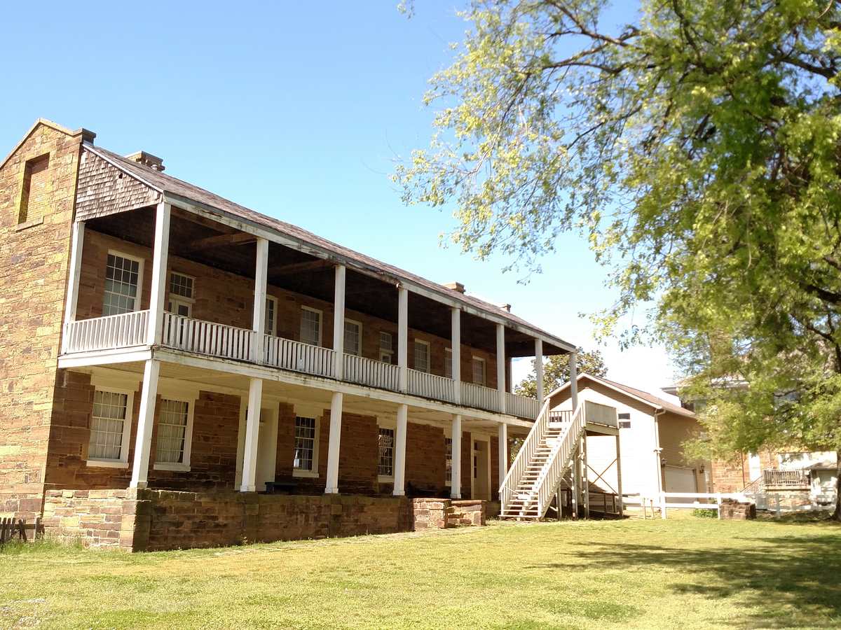 A two story house with a wide wraparound veranda