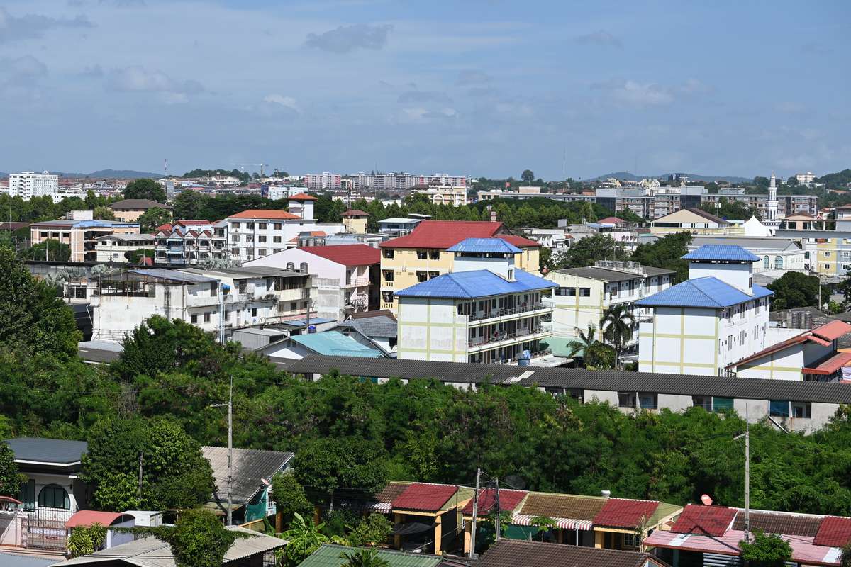 A sunny suburban neighborhood with colorful rooftops