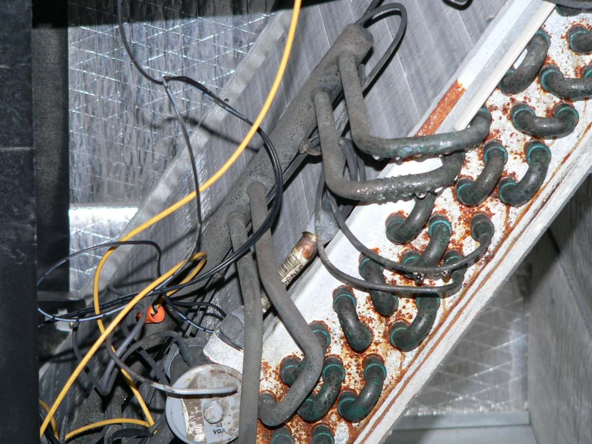 Corroded evaporator coil and condensate lines inside an air handler