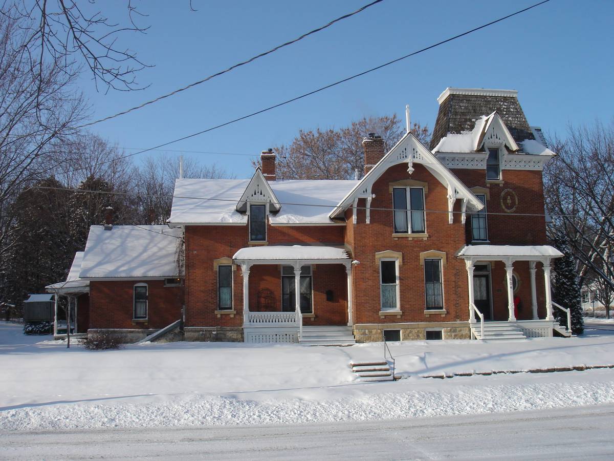 A historic brick home in Jenks, Oklahoma, under winter snow