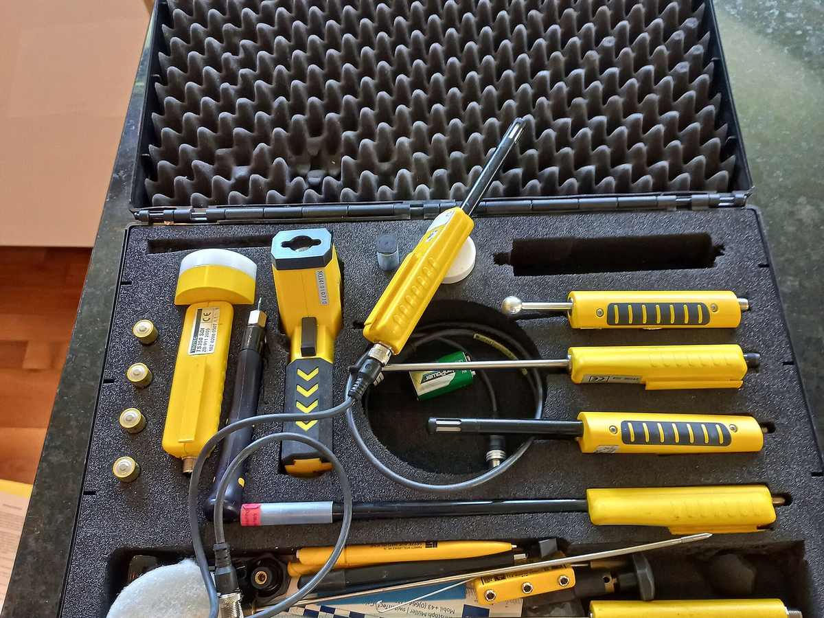 A professional moisture detection kit with meters and probes laid out in its case
