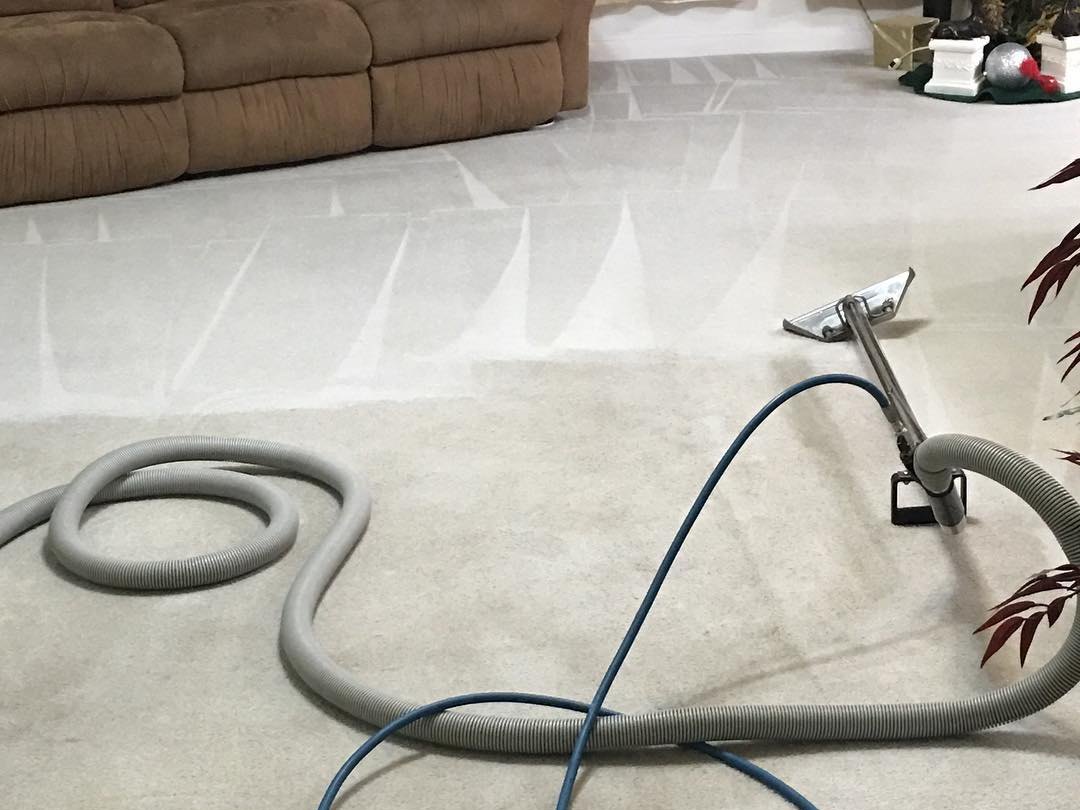 Carpet deep cleaning wand and hoses working across a living room carpet in Tulsa