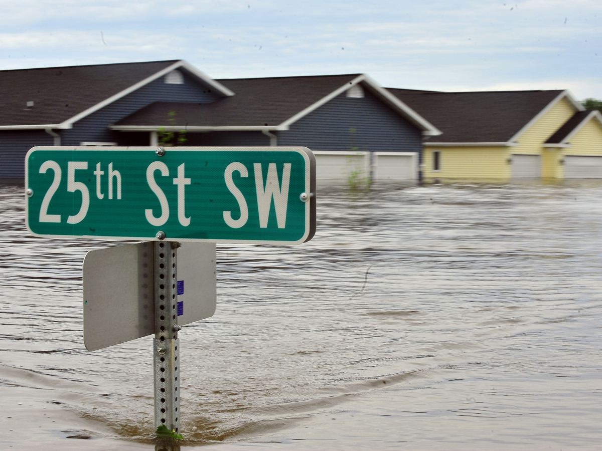 A flooded residential street with homes standing in high water