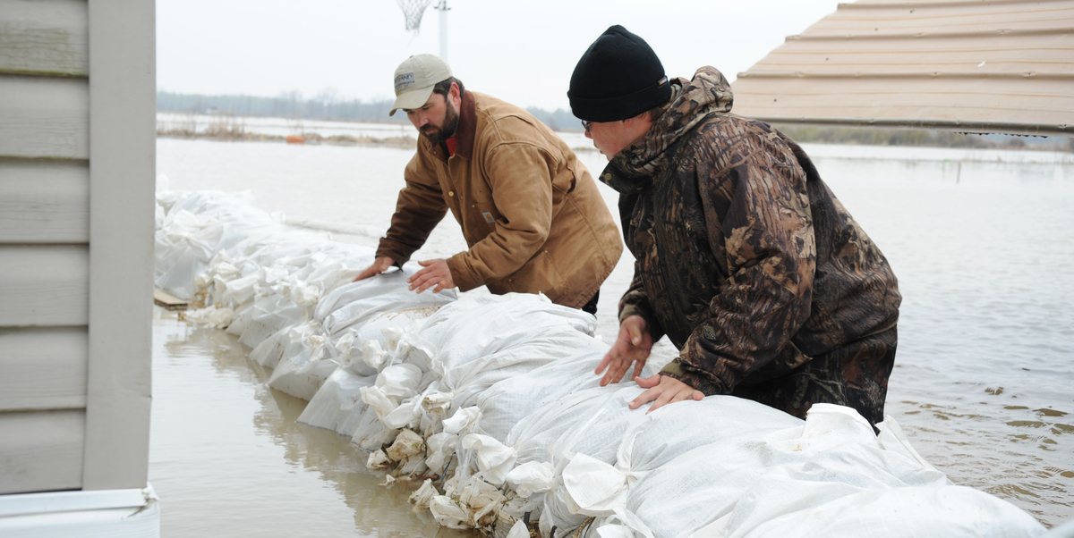 Residents building a sandbag wall against rising floodwater
