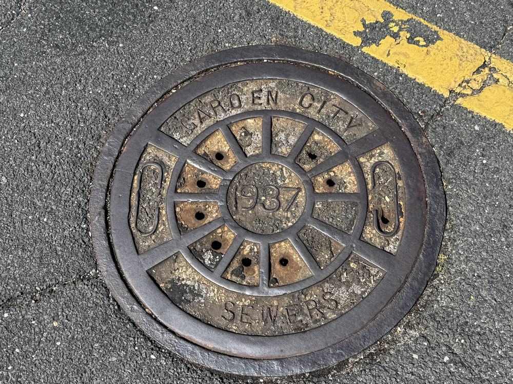 A sanitary sewer manhole cover set into a street
