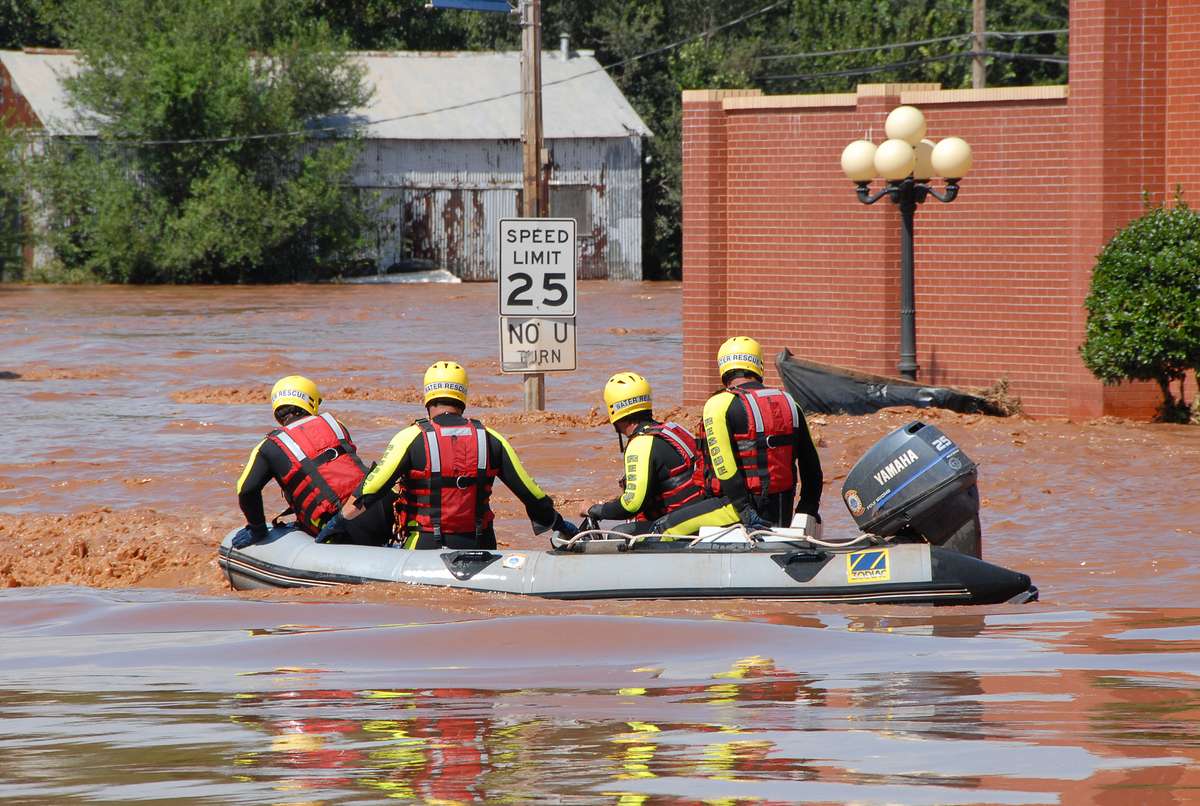 A rescue boat crew crossing a flooded street after a storm