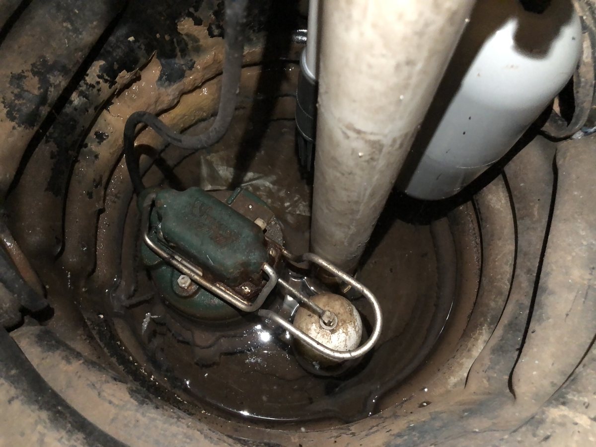 A newly installed sump pump in a basement pit