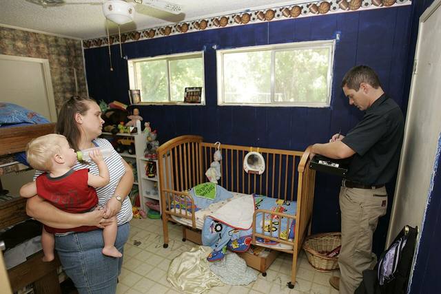 Damage inspector documenting a water damaged home interior with the homeowner for an insurance claim