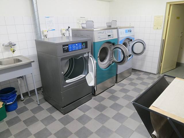 Front-load washing machines in a bright laundry room, the appliances behind most Tulsa laundry room floods