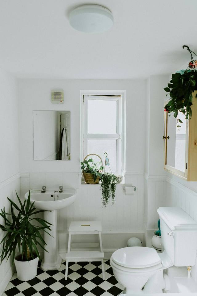 Bright bathroom with toilet and pedestal sink in a Tulsa OK home, a room where overflow water extraction commonly begins