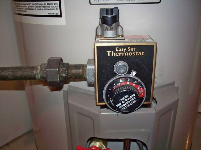Gas control valve and thermostat dial on a tank water heater, checked first when a Tulsa water heater starts to leak