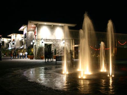 Fountains lit at night at Jenks RiverWalk on the Arkansas River