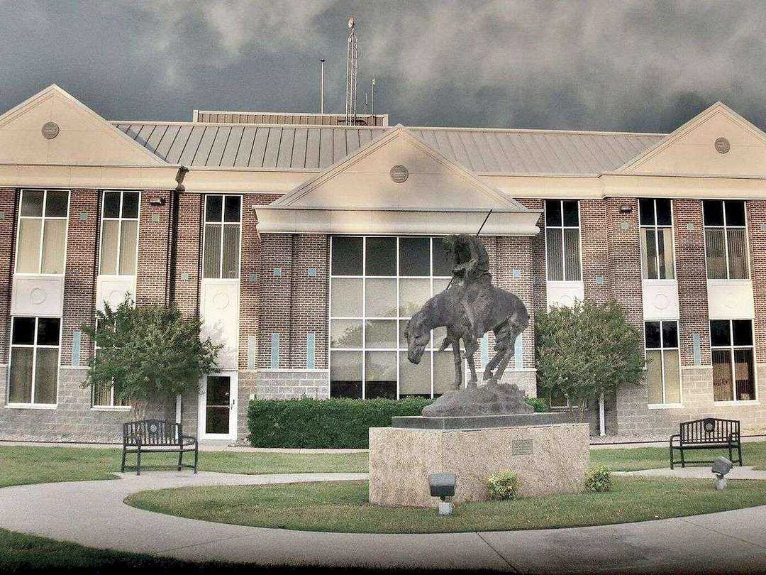 Owasso City Hall in Owasso, Oklahoma, with a bronze statue on the lawn in front