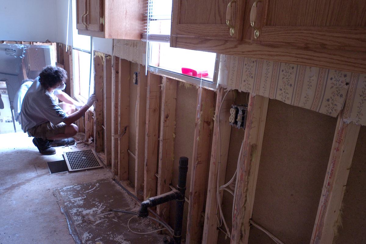 A volunteer removing damaged material inside a flood damaged home