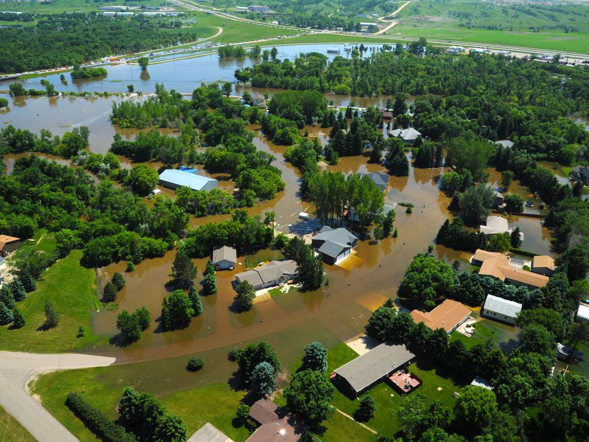 Aerial view of floodwater winding through a residential neighborhood, the outside water a flood policy addresses