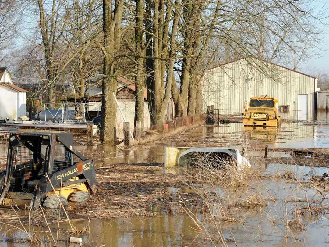 Floodwater covering open land with a vehicle partly submerged